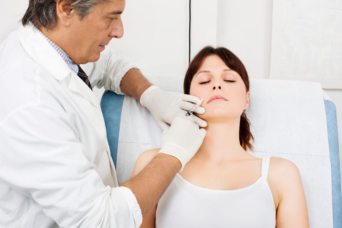 Doctor administering facial injection during Medical Esthetics Diploma Program training