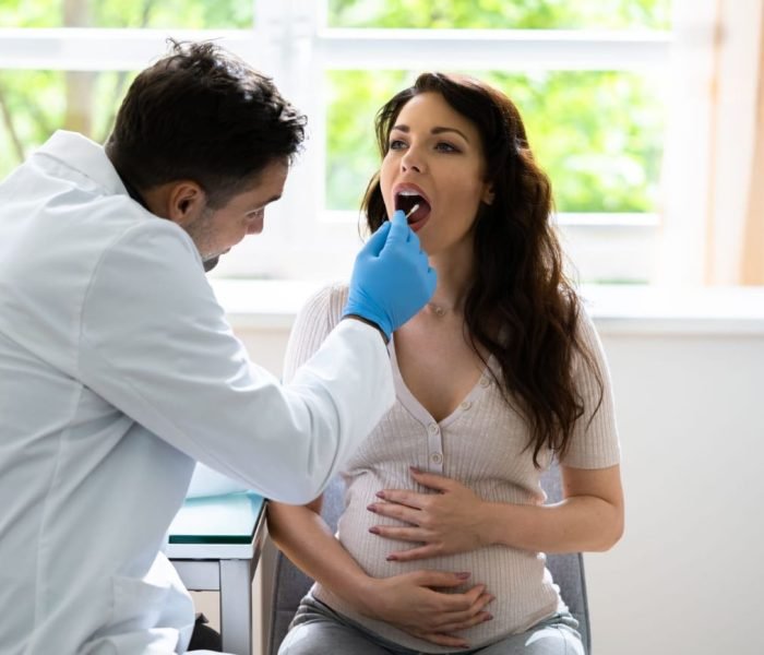 Close-up of a woman undergoing DNA testing with a mouth swab