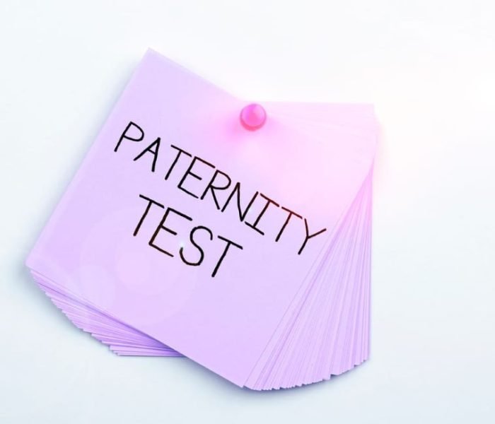 Stack of purple notes pinned with the words 'Paternity Test' written on top
