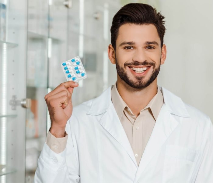 handsome-pharmacist-smiling-at-camera-while-holdin-2023-11-27-05-12-27-utc.jpg